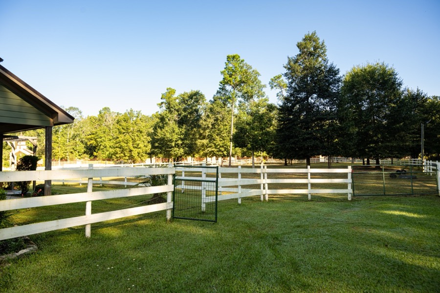 White split-rail fencing along Inspira Ranch property with mature oak canopy at golden hour