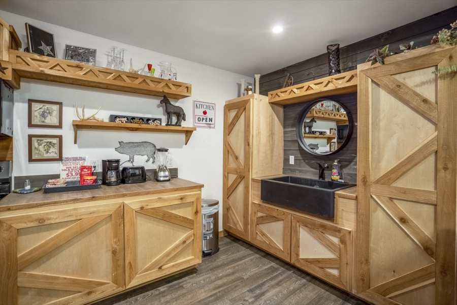 Inspira Ranch barndominium hand-crafted wood bar with X-pattern cabinetry and farmhouse sink