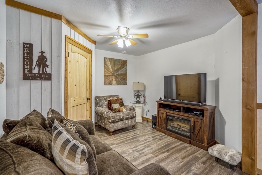 Inspira Ranch barndominium living room with sectional sofa, large TV, and western ranch decor